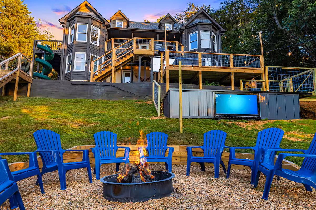 Vacation rental at sunset with a fire pit ring and a glowing container pool