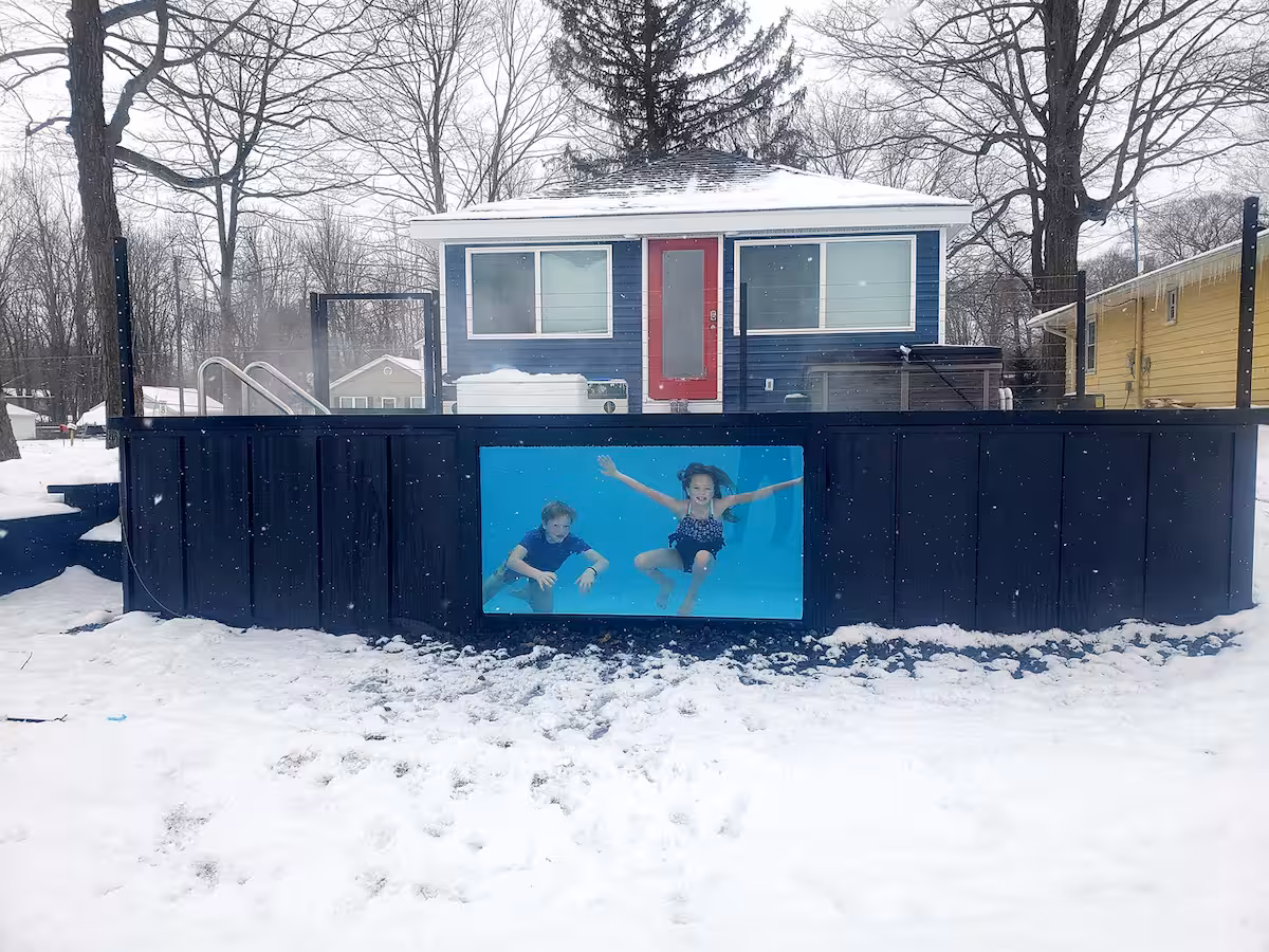 Heated container pool with a lit acrylic viewing window surrounded by deep snow